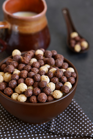 Healthy breakfast. Chocolate breakfast cereal with milk on a black background.の写真素材