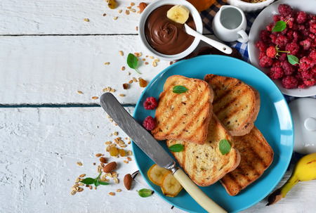 Good morning - toast with walnut, chocolate paste, banana and honey. White food background.の写真素材
