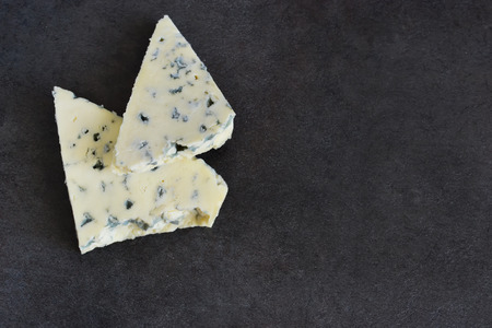 Slice of blue cheese on a black backgroundの写真素材