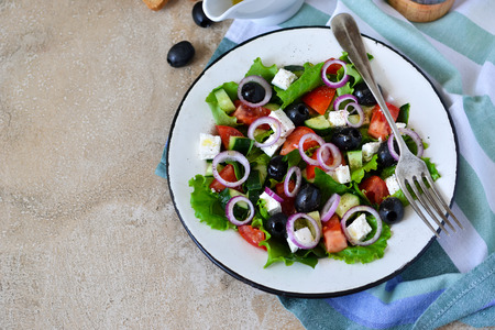 Classic Greek salad with sauce on a concrete background. Greek cuisine.の写真素材