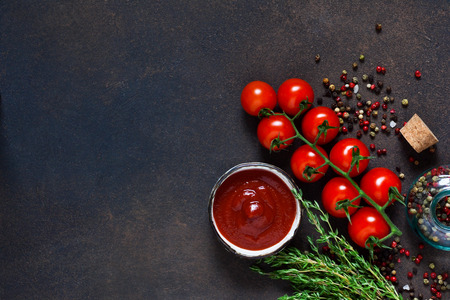 Tomato sauce with thyme, chili pepper and paprika on a dark background.の写真素材