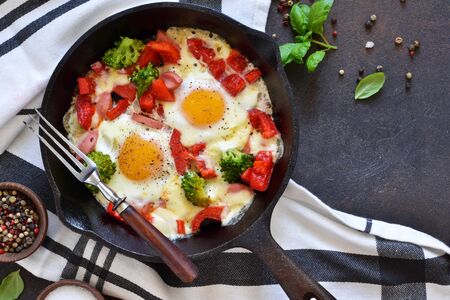 Fried eggs with tomatoes, peppers and broccoli for breakfast on the kitchen table. Good morning.の写真素材