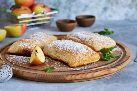 Puffs with apples and cinnamon in a plate on the kitchen table. の写真素材