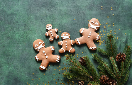 New year concept. Fir and gingerbread cookies on a green concrete background. View from above.