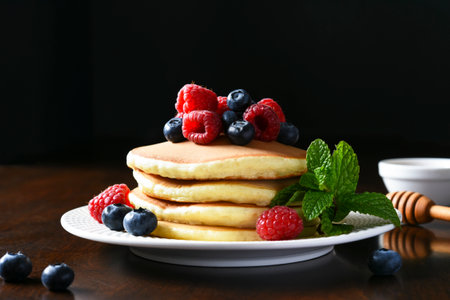 Pancakes with raspberries and blueberries with honey. Morning,pancakes for breakfastの写真素材