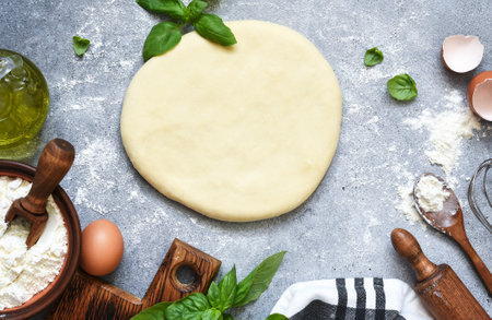 The process of making fakachi, flour and basil. Ingredients for making pizza dough. Top view with space for text.の写真素材