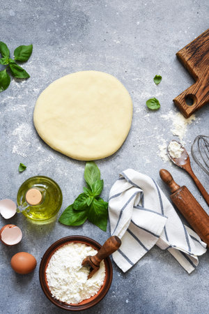 The process of making fakachi, flour and basil. Ingredients for making pizza dough. Top view with space for text.の写真素材