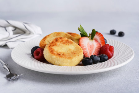 Cheese pancake with strawberries on a light background for breakfastの写真素材