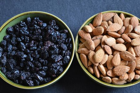 black raisins and almonds two bowlsの写真素材