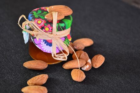 jar honey and almonds on the checkered fabricの写真素材