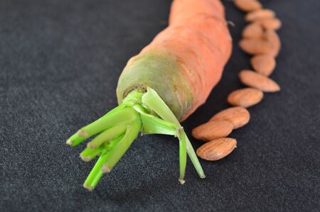 carrot and almonds on the black backgroundの写真素材