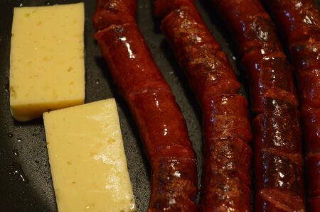 sausage and cheese on a grillの写真素材
