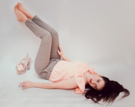 Beautiful, sexy brunette in trousers and a pink blouse.の写真素材