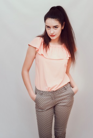 Beautiful, sexy brunette in trousers and a pink blouse.の写真素材