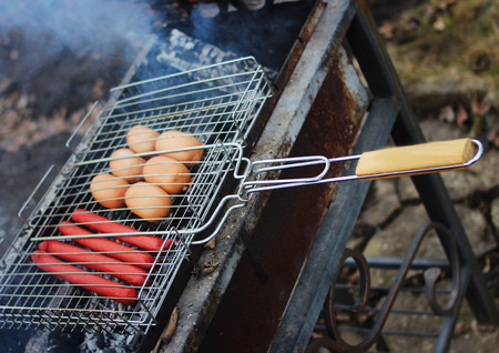 Very tasty grilled sausages on a grill in the smoke.の写真素材