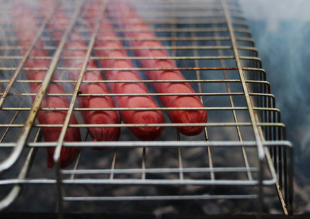 Very tasty grilled sausages on a grill in the smoke.の写真素材