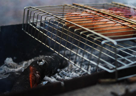 Very tasty grilled sausages on a grill in the smoke.の写真素材