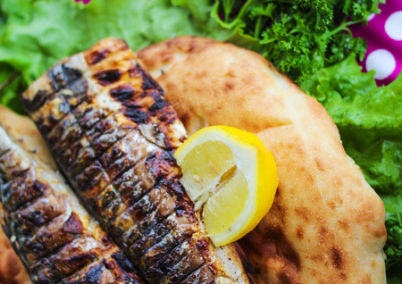 Fried fish with herbs served on breadの写真素材
