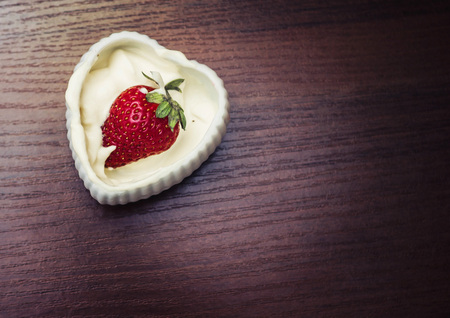 Strawberries in cream in the form of heartの写真素材