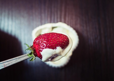 A strawberry with cream on a teaspoon, very tasty food.の写真素材