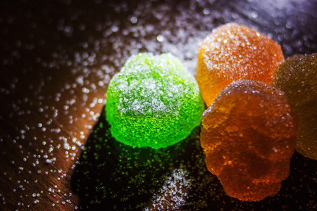 Multicolored marmalade in sugar on a dark background.の写真素材