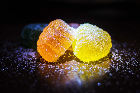 Multicolored marmalade in sugar on a dark background.の写真素材