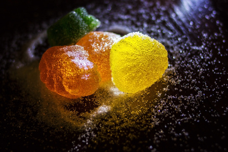 Multicolored marmalade in sugar on a dark background.の写真素材