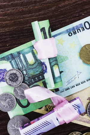 Euros of different denominations twisted into a tubeの写真素材