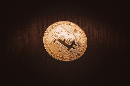 Crypto currency in gold. Gold coin bitcoin close-up against a dark wood background.の写真素材