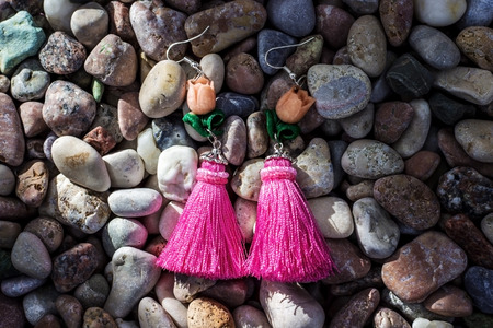 Earrings-brushes lying on sea stones of different colors. Earrings handmade. Sergi of silk thread and silver.の写真素材