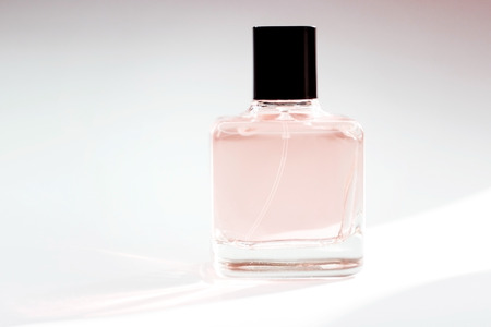 A bottle of spirits of pink color on a white background. Transparent bottle of perfume. Perfume on white.の写真素材