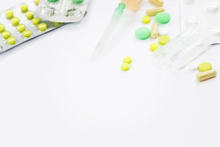 Pills, syringe and various medical preparations on a white background. Place for the text of the pledges. Background for medical subjects. Texture with medicines.の写真素材