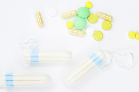 Tampons and pills on a white background. Background and texture for medecine.の写真素材