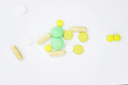 close up white medicine tablets-pills scattered on white background from light protect drug plastic...