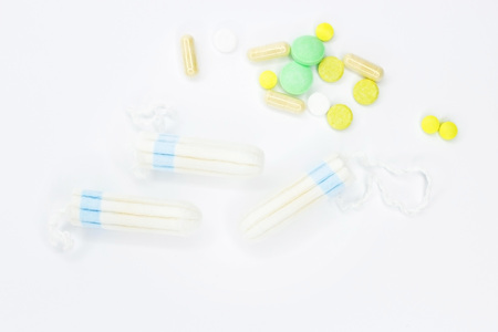 Tampons and pills on a white background. Background and texture for medecine.の写真素材