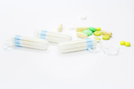 Tampons and pills on a white background. Background and texture for medecine.の写真素材