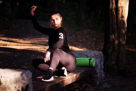 young beautiful and fit sport woman looking at mobile phone internet app tracking performance after running workout sitting on park bench happy and relaxed in healthy lifestyle concept.の写真素材