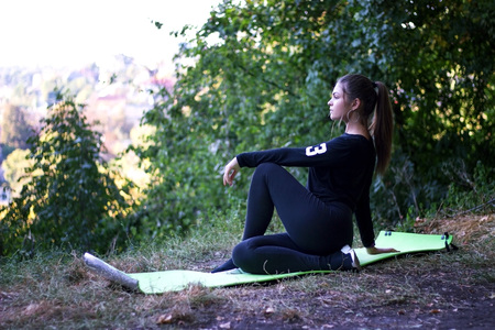 Beautiful thin woman sportswoman doing the exercise, makes twisting on the press on a yoga mat on a...
