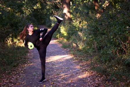 Young woman stretching and warming up at park during sunset. Attractive girl stretching before...