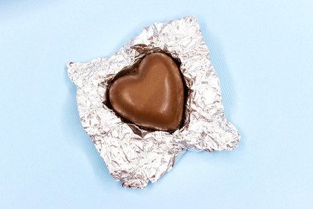 Chocolate hearts in a foil on a blue backgroundの写真素材