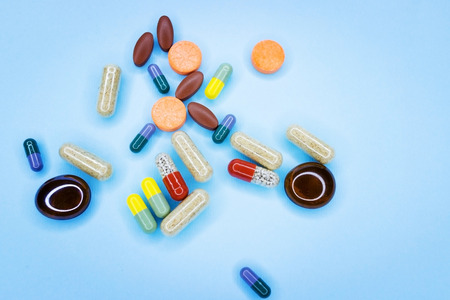 A photo of different medical drugs, tablets and pills on blue background Pretty pills.の写真素材