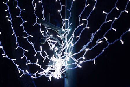 Christmas garland at night in the park on the column