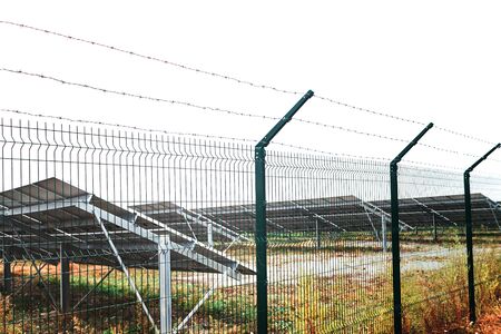 Solar panels behind the fence, barbed wire around solar panels.の写真素材