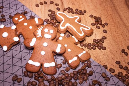 Smiling gingerbread man standing next to flour sifter with baking ingredients and additional...