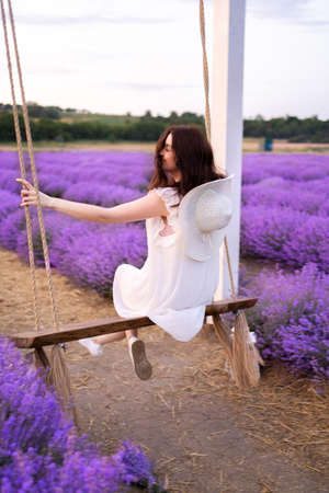 Girl on a swing in lavender in summerの写真素材