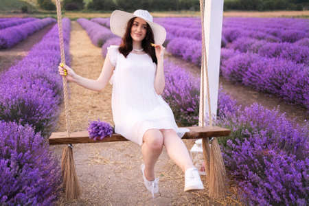 Girl on a swing in lavender in summerの写真素材
