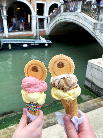 Delicious icecream in beautiful Venezia, Italy in front of a canal and historic buildingsの写真素材
