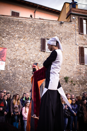 Juggler with stilts makes a show in the square in an Italian town during a medieval event. Tuscany - Italyのeditorial素材