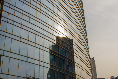 Unicredit skyscraper in the financial center of Milan. The mirrored windows reflect the sun and the buildings in front. Milan 02/22/2018の写真素材