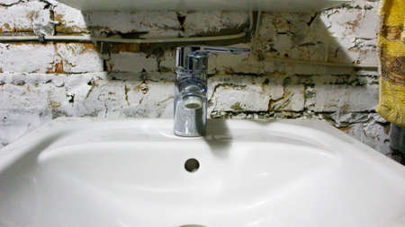 Chrome plated faucet and wash basin water flows from the faucet into the sink